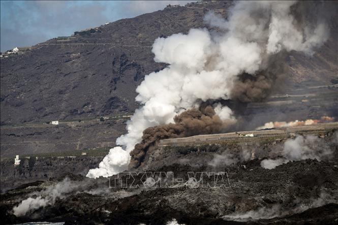 Trong ảnh: Dung nham phun trào từ núi lửa Cumbre Vieja trên đảo La Palma thuộc quần đảo Canary (Tây Ban Nha) chảy ra biển ngày 22/11/2021. Ảnh: AFP/TTXVN