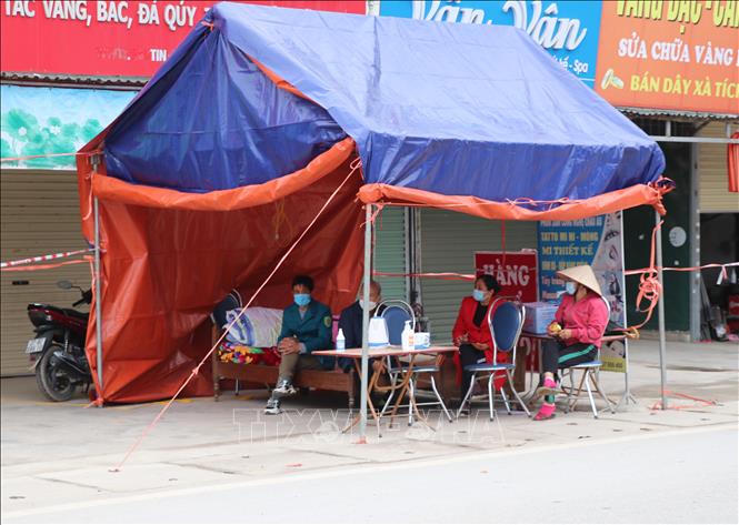 Trong ảnh: Để thực hiện phong tỏa khu vực chợ Bản Phủ, chính quyền địa phương đã thiết lập 2 chốt kiểm soát ở 2 cổng ra, vào chợ. Lực lượng tham gia là Ban quản lý chợ, lượng y tế và các cán bộ đoàn thể. Ảnh: Xuân Tiến - TTXVN 