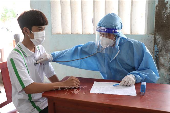 Các học sinh tại Trung tâm giáo dục thường xuyên và nghề nghiệp Ba Tri, huyện Ba Tri, tỉnh Bến Tre được khám sàng lọc, đo nhiệt độ trước khi tiêm vaccine phòng COVID-19. Ảnh: Chương Đài - TTXVN