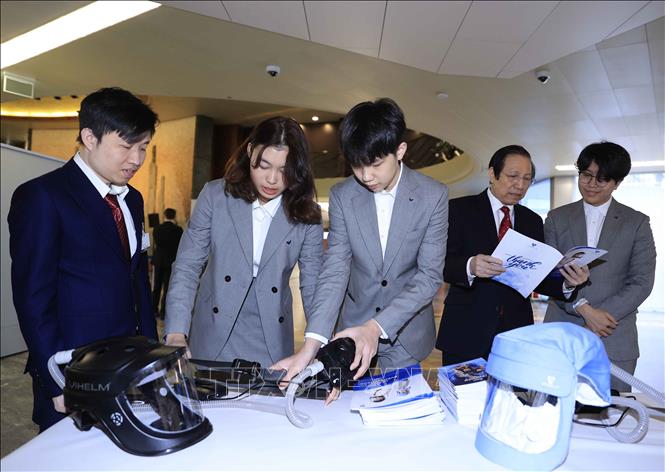 Photo: Inventors of Vihelm explain their invention. They designed a helmet connected to a respirator that not only protects but also allows frontline workers to work more effectively. VNA Photo: Thống Nhất