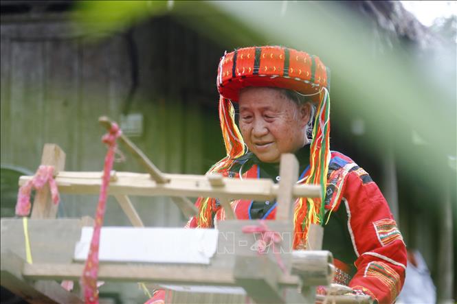 Photo: Hung Thi Chang, a 70-year-old brocade weaving artisan, focusing on her loom. VNA Photo: Nam Sương