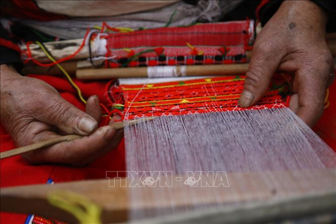 Photo: Skillful hands of a brocade weaving artisan at work. VNA Photo: Nam Sương