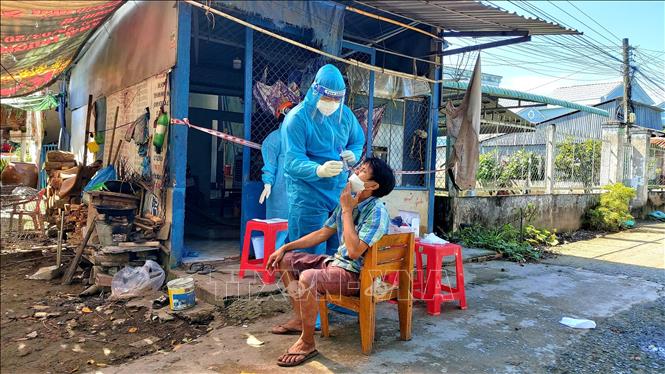Trong ảnh: Sinh viên Trường ĐHYD Cần Thơ Trần Ngô Quang, Đội Y tế lưu động số 51 tham gia hỗ trợ phường Phước Thới, quận Ô Môn lấy mẫu test định kỳ cho F1,F0 tại nhà. Ảnh: Thu Hiền - TTXVN