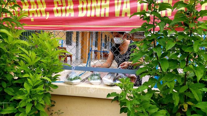 Trong ảnh: Chị Nguyễn Thị Diễm Trang, Trưởng Trạm Y tế xã Định Môn (huyện Thới Lai) đang phải cách ly, điều trị và làm việc tại Trạm nhận thực phẩm từ người thân gửi vào. Ảnh: Thu Hiền - TTXVN