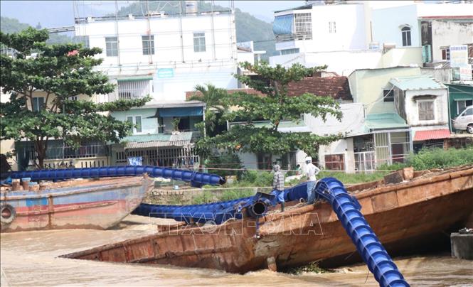 Hai chiếc xà lan cỡ lớn trôi từ thượng nguồn sông Cái và mắc kẹt tại khu vực cầu Hà Ra, thành phố Nha Trang ngày 1/12. Ảnh: Tiên Minh - TTXVN