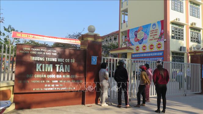 Trong ảnh: Phụ huynh Trường THCS Kim Tân, thành phố Lào Cai ở ngoài cổng trường đợi con em mình lấy mẫu xét nghiệm COVID-19. Ảnh: TTXVN/phát
