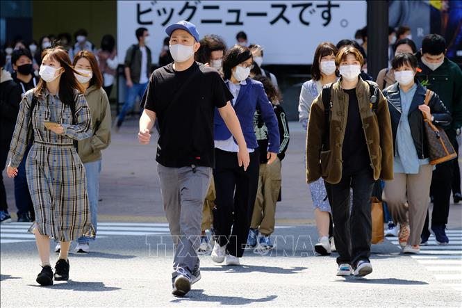 Trong ảnh: Người dân di chuyển trên đường phố tại Tokyo, Nhật Bản. Ảnh: AFP/ TTXVN