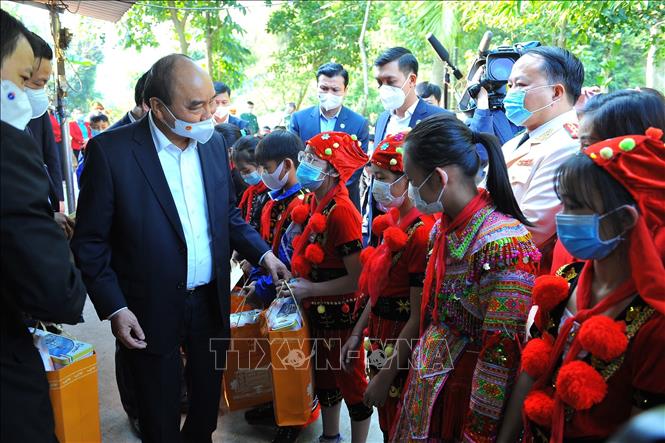 Trong ảnh: Chủ tịch nước Nguyễn Xuân Phúc tặng quà cho các cháu học sinh có hoàn cảnh khó khăn. Ảnh: Minh Đức - TTXVN