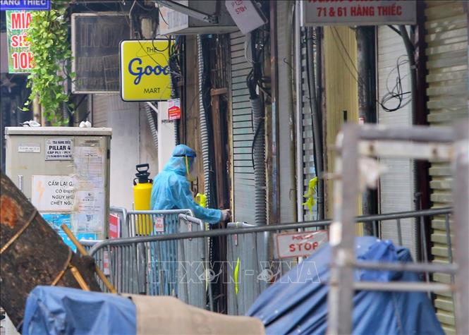 Nhân viên y tế phun khử khuẩn tại các hộ gia đình trên phố Hàng Thiếc (phường Hàng Gai, quận Hoàn Kiếm). Ảnh: Tuấn Đức - TTXVN