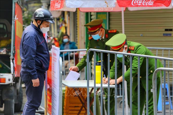 Lực lượng chức năng kiểm soát việc tiếp tế tại phố Hàng Thiếc (phường Hàng Gai, quận Hoàn Kiếm). Ảnh: Tuấn Đức - TTXVN