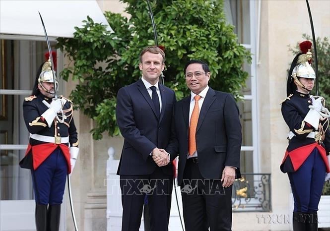 Photo: On the framework of his official visit to France, Prime Minister Pham Minh Chinh (R) receives President Emmanuel Macron on November 4, 2021. VNA Photo: Dương Giang