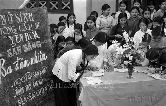 Phong trào phụ nữ “Ba đảm đang” năm 1965 nhanh chóng phát triển thành cao trào cách mạng sôi nổi, rộng lớn, huy động được sức mạnh tổng hợp của hàng chục triệu phụ nữ từ nông thôn tới thành thị, từ miền ngược đến miền xuôi, trên mọi lĩnh vực hoạt động. Trong ảnh: Học sinh trường cấp III Yên Hòa, Hà Nội đăng ký phong trào “Ba đảm nhiệm”, sau này là phong trào phụ nữ “Ba đảm đang”. Ảnh: Thanh Tụng – TTXVN