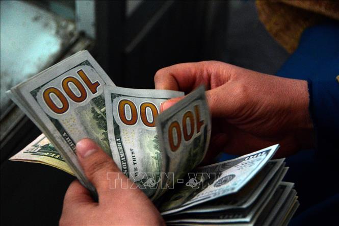 Trong ảnh: Giao dịch đổi tiền đôla Mỹ tại một khu chợ ở thành phố Kandahar, Afghanistan ngày 14/12/2021. Ảnh: THX/TTXVN