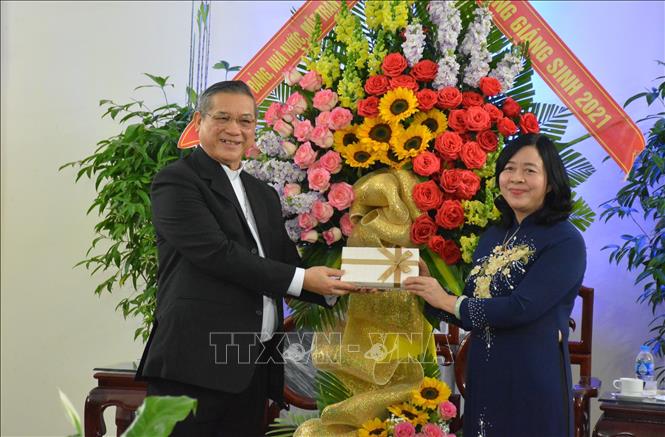 Photo: Head of the Party Central Committee’s Commission for Mass Mobilisation Bui Thi Minh Hoai presents flowers and gifts to Bishop Vu Dinh Hieu. VNA Photo: Công Luật