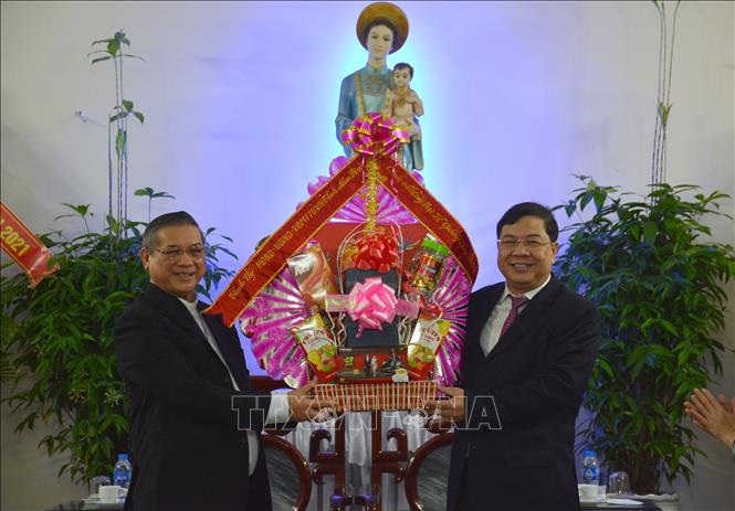 Photo: Secretary of the Nam Dinh provincial Party Committee Pham Gia Tuc presents flowers and gifts to Bishop Vu Dinh Hieu. VNA Photo: Công Luật