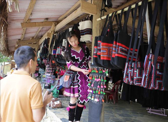 Trong ảnh: Du khách lựa chọn sản phẩm thêu dệt thủ công làm quà lưu niệm tại chợ phiên Sin Suối Hồ. Ảnh: Quý Trung – TTXVN