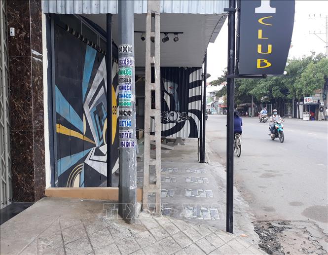 Trong ảnh: “Vỉa hè không lối thoát” do bảng hiệu và cột điện chắn lối đi tại một club trên đường 21/8 (phường Phước Mỹ). Ảnh: Nguyễn Thành – TTXVN
