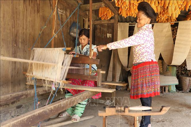 Trong ảnh: Phụ nữ Mông từ khi còn nhỏ đã được bà hoặc mẹ dạy cho cách dệt vải thổ cẩm truyền thống. Ảnh: Tiến Khánh - TTXVN