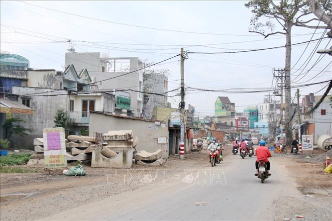 Trong ảnh: Đoạn gần nút giao Đặng Thúc Vịnh – Tô Ký vẫn còn một số hộ dân chưa bàn giao mặt bằng, gây khó khăn cho mục tiêu thông xe dự án Đặng Thúc Vịnh trước Tết Nguyên đán. Ảnh: Tiến Lực – TTXVN