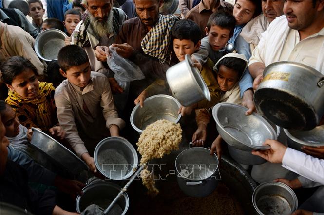 Tại Hội nghị viện trợ quốc tế cho Afghanistan ở Geneva, Thụy Sĩ ngày 13/9/2021, các nước tài trợ cam kết hỗ trợ nhân đạo 1,2 tỷ USD cho Afghanistan nhằm giúp quốc gia này đối phó với cuộc khủng hoảng kinh tế nghiêm trọng sau khi Taliban lên nắm quyền. Tổng Thư ký LHQ Antonio Guterres nhấn mạnh, sau hàng chục năm chiến tranh và bất ổn, 14 triệu người Afghanistan có nguy cơ đói và hệ thống y tế bên bờ vực sụp đổ. Trong ảnh: Trẻ em Afghanistan chờ nhận thực phẩm viện trợ tại Jalalabad. Ảnh: AFP/TTXVN