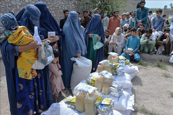 Tại Hội nghị viện trợ quốc tế cho Afghanistan ở Geneva, Thụy Sĩ ngày 13/9/2021, các nước tài trợ cam kết hỗ trợ nhân đạo 1,2 tỷ USD cho Afghanistan nhằm giúp quốc gia này đối phó với cuộc khủng hoảng kinh tế nghiêm trọng sau khi Taliban lên nắm quyền. Tổng Thư ký LHQ Antonio Guterres nhấn mạnh, sau hàng chục năm chiến tranh và bất ổn, 14 triệu người Afghanistan có nguy cơ đói và hệ thống y tế bên bờ vực sụp đổ. Trong ảnh: Người dân chờ nhận lương thực cứu trợ tại Jalalabad, Afghanistan, ngày 20/4/2021. Ảnh: AFP/TTXVN