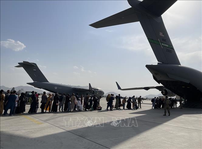 Mỹ hoàn tất việc rút quân, để lại một Afghanistan đối mặt rất nhiều thách thức trong bối cảnh Taliban đang cố gắng xây dựng chính phủ mới sau khi giành quyền kiểm soát Kabul. Nguy cơ trỗi dậy của chủ nghĩa khủng bố, xung đột bạo lực từ tình trạng chia rẽ đất nước không chỉ đe dọa trong phạm vi lãnh thổ Afghanistan, mà có thể sẽ rất nhanh chóng tác động tới cục diện, tình hình an ninh tại nhiều quốc gia trong khu vực. Trong ảnh: Các công dân xếp hàng chờ lên máy bay quân sự Mỹ ở sân bay quốc tế Kabul để rời khỏi Afghanistan, ngày 22/8/2021. Ảnh: THX/TTXVN
