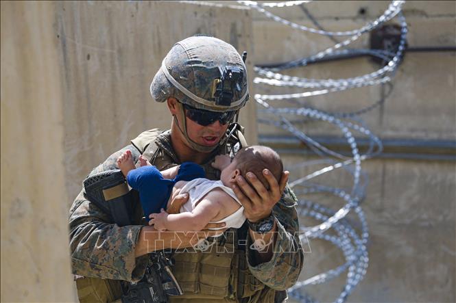 Mỹ hoàn tất việc rút quân, để lại một Afghanistan đối mặt rất nhiều thách thức trong bối cảnh Taliban đang cố gắng xây dựng chính phủ mới sau khi giành quyền kiểm soát Kabul. Nguy cơ trỗi dậy của chủ nghĩa khủng bố, xung đột bạo lực từ tình trạng chia rẽ đất nước không chỉ đe dọa trong phạm vi lãnh thổ Afghanistan, mà có thể sẽ rất nhanh chóng tác động tới cục diện, tình hình an ninh tại nhiều quốc gia trong khu vực. Trong ảnh: Binh sĩ Mỹ hỗ trợ việc sơ tán của người dân Afghanistan ở sân bay quốc tế Kabul, ngày 21/8/2021. Ảnh: AFP/TTXVN 