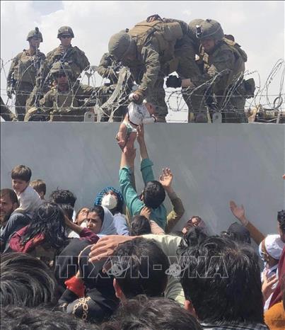 Mỹ hoàn tất việc rút quân, để lại một Afghanistan đối mặt rất nhiều thách thức trong bối cảnh Taliban đang cố gắng xây dựng chính phủ mới sau khi giành quyền kiểm soát Kabul. Nguy cơ trỗi dậy của chủ nghĩa khủng bố, xung đột bạo lực từ tình trạng chia rẽ đất nước không chỉ đe dọa trong phạm vi lãnh thổ Afghanistan, mà có thể sẽ rất nhanh chóng tác động tới cục diện, tình hình an ninh tại nhiều quốc gia trong khu vực. Trong ảnh: Binh sĩ Mỹ hỗ trợ việc sơ tán của người dân Afghanistan ở sân bay quốc tế Kabul, ngày 19/8/2021. Ảnh: AFP/TTXVN 