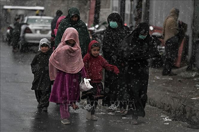Trong ảnh: Phụ nữ và trẻ em di chuyển trên đường phố tại Kabul, Afghanistan, ngày 15/12/2021. Ảnh: AFP/TTXVN