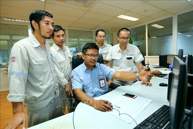 Trong ảnh: Phó Giám đốc Công ty CP xi măng Thăng Long Eko Budiono (người Indonesia, ngồi giữa) đang trao đổi nghiệp vụ với các kĩ sư người Việt Nam tại phòng điều khiển trung tâm của nhà máy của Công ty CP Xi măng Thăng Long. Ảnh: Danh Lam – TTXVN
