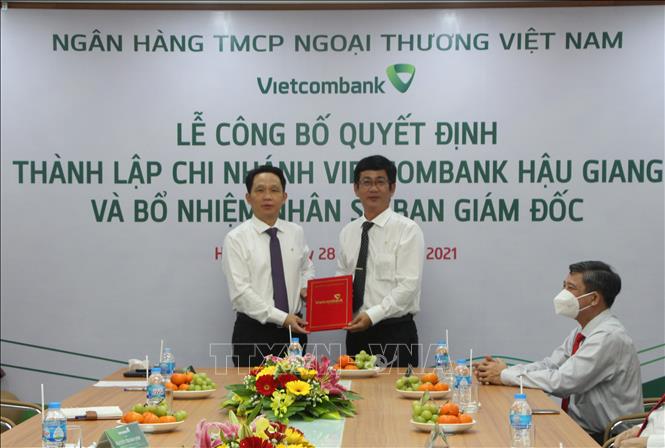 Trong ảnh: Ông Nguyễn Mạnh Hùng (trái), Ủy viên HĐQT Vietcombank trao quyết định thành lập Chi nhánh Vietcombank Hậu Giang cho Giám đốc Chi nhánh. Ảnh: Hồng Thái - TTXVN
