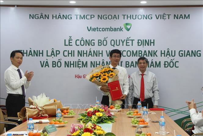 Trong ảnh:Chủ tịch UBND tỉnh Hậu Giang Đồng Văn Thanh (phải) tặng hoa chúc mừng ông Huỳnh Thanh Vũ, Giám đốc Chi nhánh. Ảnh: Hồng Thái - TTXVN