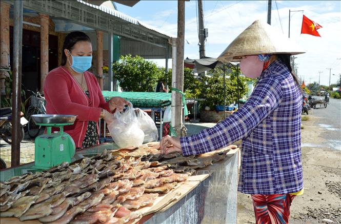 Photo: A local buying dry fish to prepare for Lunar New Year. VNA Photo: Nhựt An