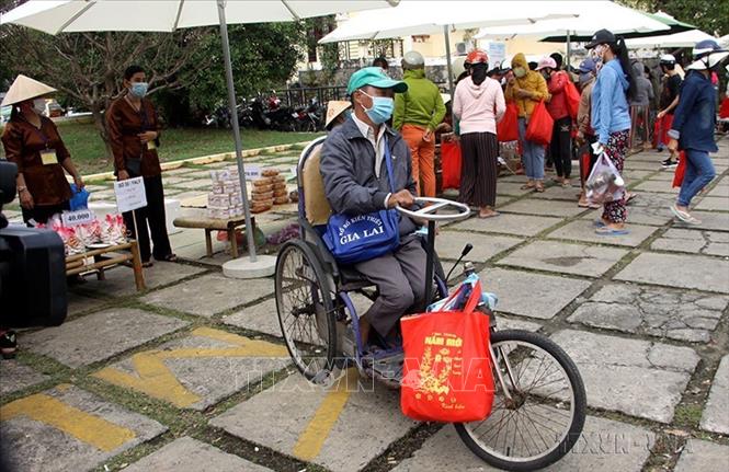 Hội thiện nguyện Tươi Sáng thành phố Hội An (Quảng Nam) phối hợp với Hiệp hội xe Du lịch Hội An tổ chức “Phiên chợ Tết không đồng” nhằm chia sẻ khó khăn với 1.000 hộ gia đình có hoàn cảnh khó khăn trên địa bàn (5/2/2021). Ảnh: Trịnh Bang Nhiệm - TTXVN