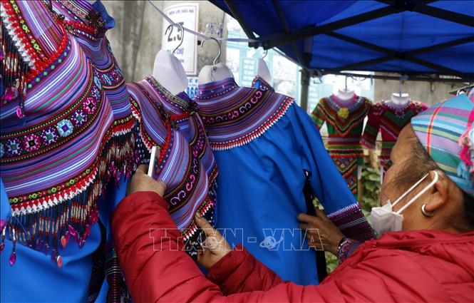 Trong ảnh: Người đồng bào chọn mua những sản phầm được làm từ chất liệu thổ cẩm. Ảnh: Quốc Khánh - TTXVN