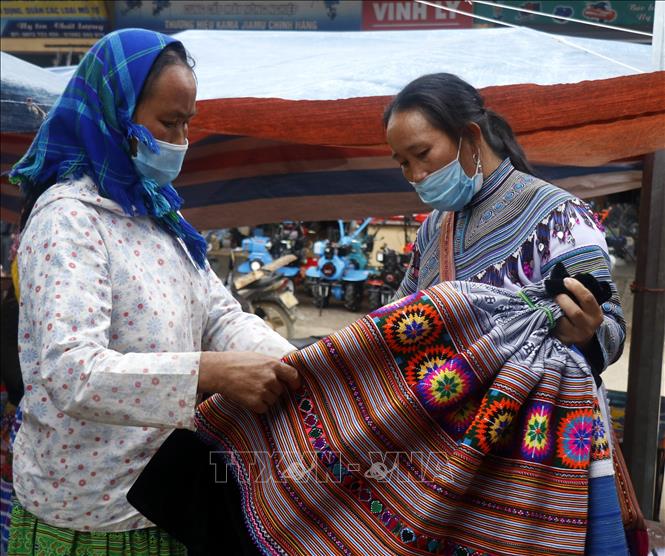 Trong ảnh: Người đồng bào chọn mua những sản phầm được làm từ chất liệu thổ cẩm. Ảnh: Quốc Khánh - TTXVN