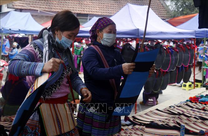 Trong ảnh: Người đồng bào chọn mua những sản phầm được làm từ chất liệu thổ cẩm. Ảnh: Quốc Khánh - TTXVN