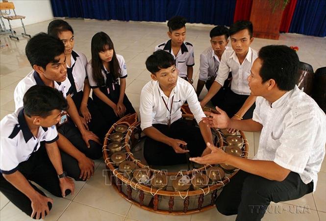 Thầy giáo dạy học sinh Trường Phổ thông Dân tộc nội trú tỉnh Bạc Liêu cách sử dụng nhạc cụ đặc trưng của đồng bào dân tộc Khmer. Ảnh: Quý Trung – TTXVN
