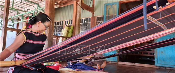 Trong ảnh:  Bà Rơ Châm Mir, dân tộc Jrai, làng Kép 2, xã Ia Mơ Nông, huyện Chư Păh (Gia Lai) vẫn miệt mài với đam mê dệt thổ cẩm từ khi còn trẻ đến nay. Ảnh: Hồng Điệp - TTXVN