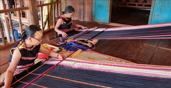 Trong ảnh:  Bà Rơ Châm Mir (phía trước) dân tộc Jrai, làng Kép 2, xã Ia Mơ Nông, huyện Chư Păh (Gia Lai) vẫn miệt mài với đam mê dệt thổ cẩm từ khi còn trẻ đến nay. Ảnh: Hồng Điệp - TTXVN