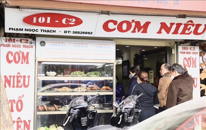 Trong ảnh: Nhiều thực khách vào quán cơm niêu trên phố Phạm Ngọc Thạch trưa 2/1. Ảnh: Hoàng Hiếu - TTXVN