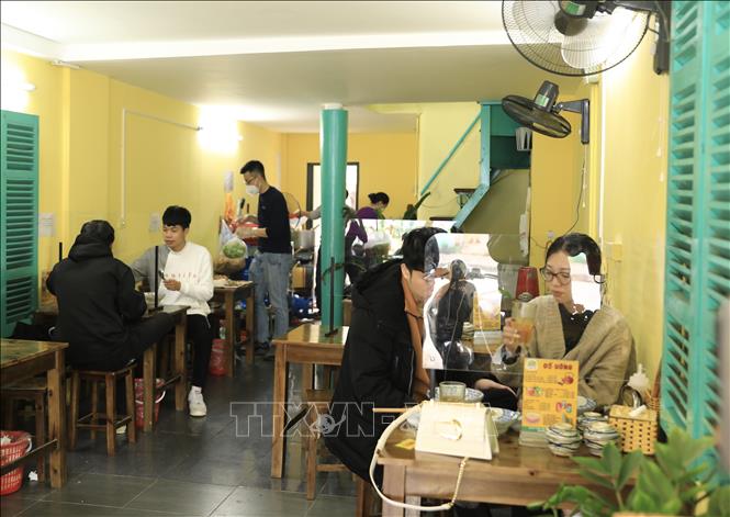 Trong ảnh: Quán bún riêu trên phố Tôn Thất Tùng được trang bị đầy đủ vách ngăn đảm bảo phòng dịch cho thực khách (ảnh chụp trưa 2/1). Ảnh: Hoàng Hiếu - TTXVN