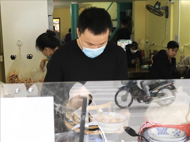 Trong ảnh: Quán bún riêu tóp mỡ trên phố Tôn Thất Tùng phục vụ thực khách ngay tại quán trưa 2/1/2022. Ảnh: Hoàng Hiếu - TTXVN