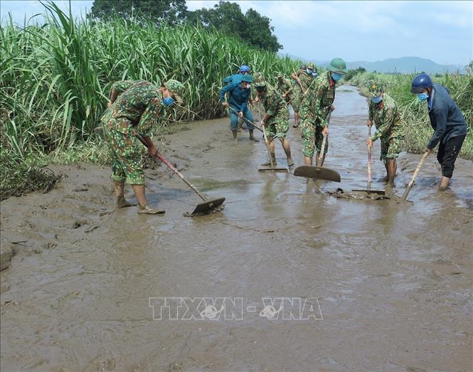 Trong ảnh: Bộ đội Phú Yên dọn bùn, đất ở các tuyến đường giao thông sau khi lũ rút. Ảnh: Xuân Triệu – TTXVN