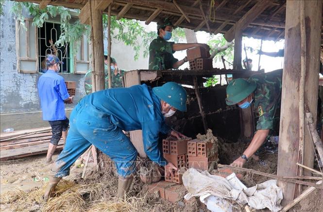Trong ảnh: Bộ đội Phú Yên giúp gia đình bà Phạm Thị Quờn (xã Sơn Hà, huyện Sơn Hòa) dọn dẹp nhà sau lũ (2021). Ảnh: Xuân Triệu – TTXVN