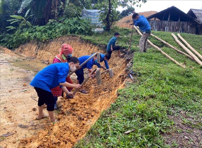 Trong ảnh: Đoàn viên thanh niên xã Xuân Lập (Tuyên Quang) hỗ trợ hộ dân ở thôn Khuẩy Trang đào đất làm nền để xây dựng chuồng trại chăn nuôi. Ảnh: Vũ Quang – TTXVN