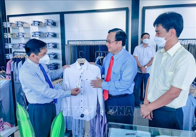 Lãnh đạo UBND TP Cần Thơ, Tổng Công ty May Việt Tiến xem sản phẩm bày bán tại cửa hàng Việt Tiến House. Ảnh: Thanh Liêm - TTXVN