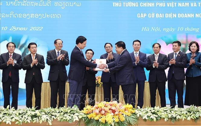 Trong ảnh: Thủ tướng Phạm Minh Chính và Thủ tướng Lào Phankham Viphavanh chứng kiến trao thoả thuận hợp tác đầu tư cho các doanh nghiệp. Ảnh: Dương Giang-TTXVN