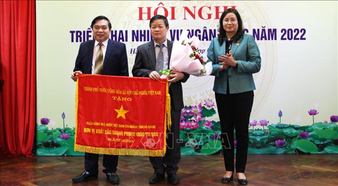 Phó Chủ tịch UBND tỉnh Hà Giang Hà Thị Minh Hạnh trao Cờ thi đua của Thủ tướng Chính phủ cho Ngân hàng Nhà nước Chi nhánh tỉnh Hà Giang. Ảnh: Minh Tâm-TTXVN