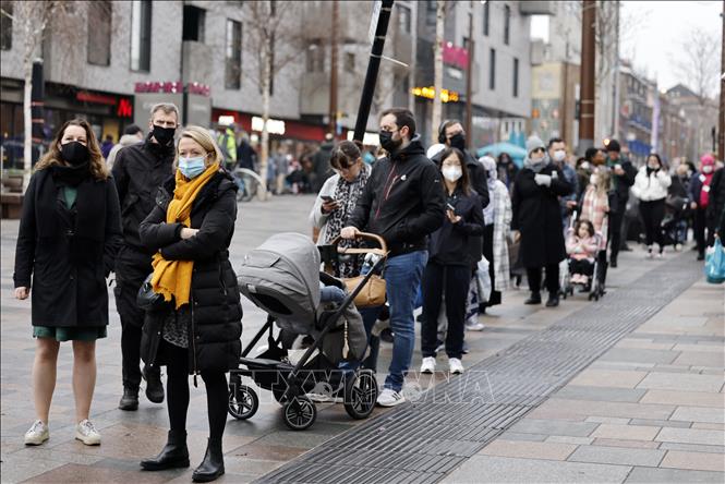 Trong ảnh: Người dân xếp hàng chờ lấy mẫu xét nghiệm COVID-19 tại London, Anh ngày 18/12/2021. Ảnh: AFP/TTXVN